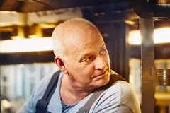 Close up - male looking behind him while sitting in a forklift
