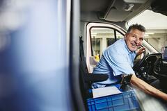 Smiling man sitting in driver's seat of a logistics truck