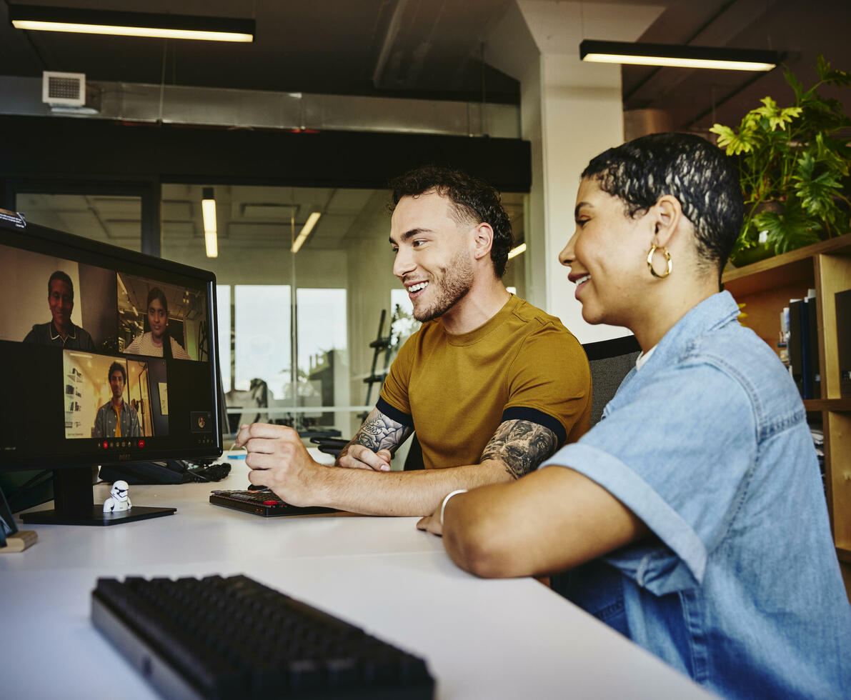 Male and female sitting behind a computer in a video meeting Male and female sitting behind a computer in a video meeting